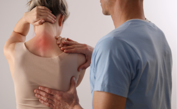 Woman with back pain. Spine physical therapist and patient. Chiropractic pain relief therapy. | Photo by Albina Gavrilovic / Getty Images (via Canva Pro) / NHA File Photo